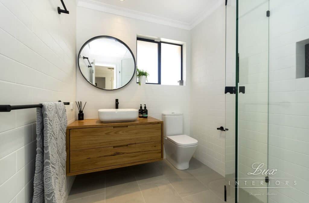 renovated bathroom with circular mirror