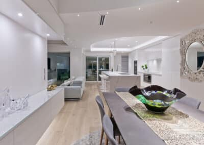 intricate details of the benchtop in the dining room with shot of kitchen and lounge
