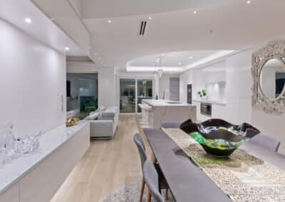 Intricate details of the benchtop in the dining room with shot of kitchen and lounge