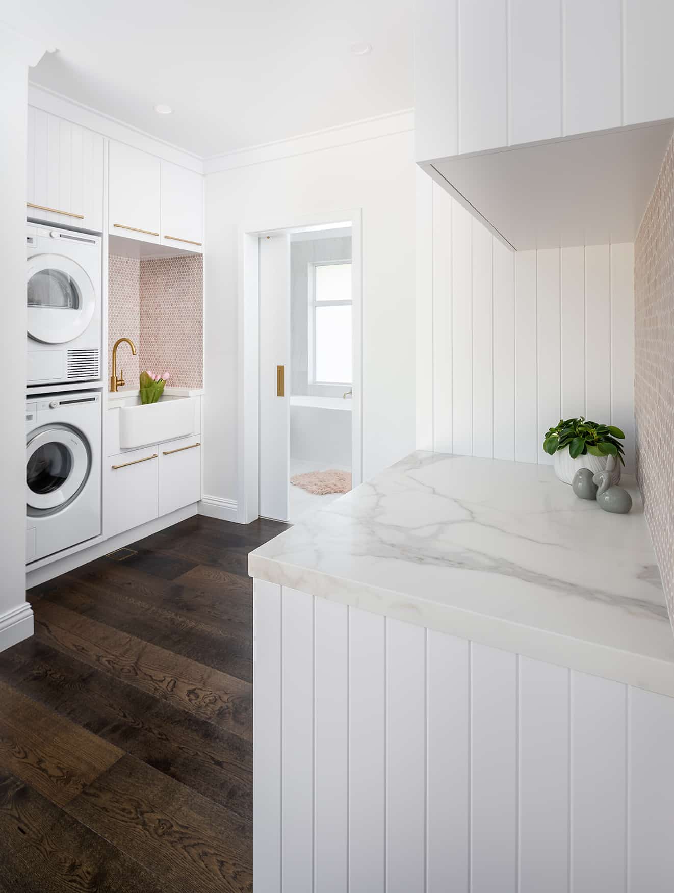 North beach coastal barn laundry renovation with brass, white v groove panelling and pink penny round tiles