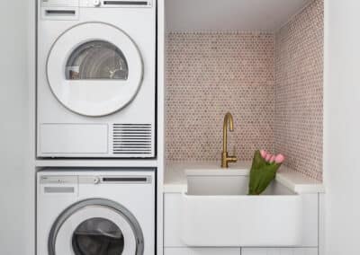 North beach coastal barn laundry renovation with brass, white v groove panelling and pink penny round tiles