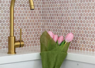 North Beach Coastal Barn Laundry with brass tapware, pink penny rounds and fresh tulips