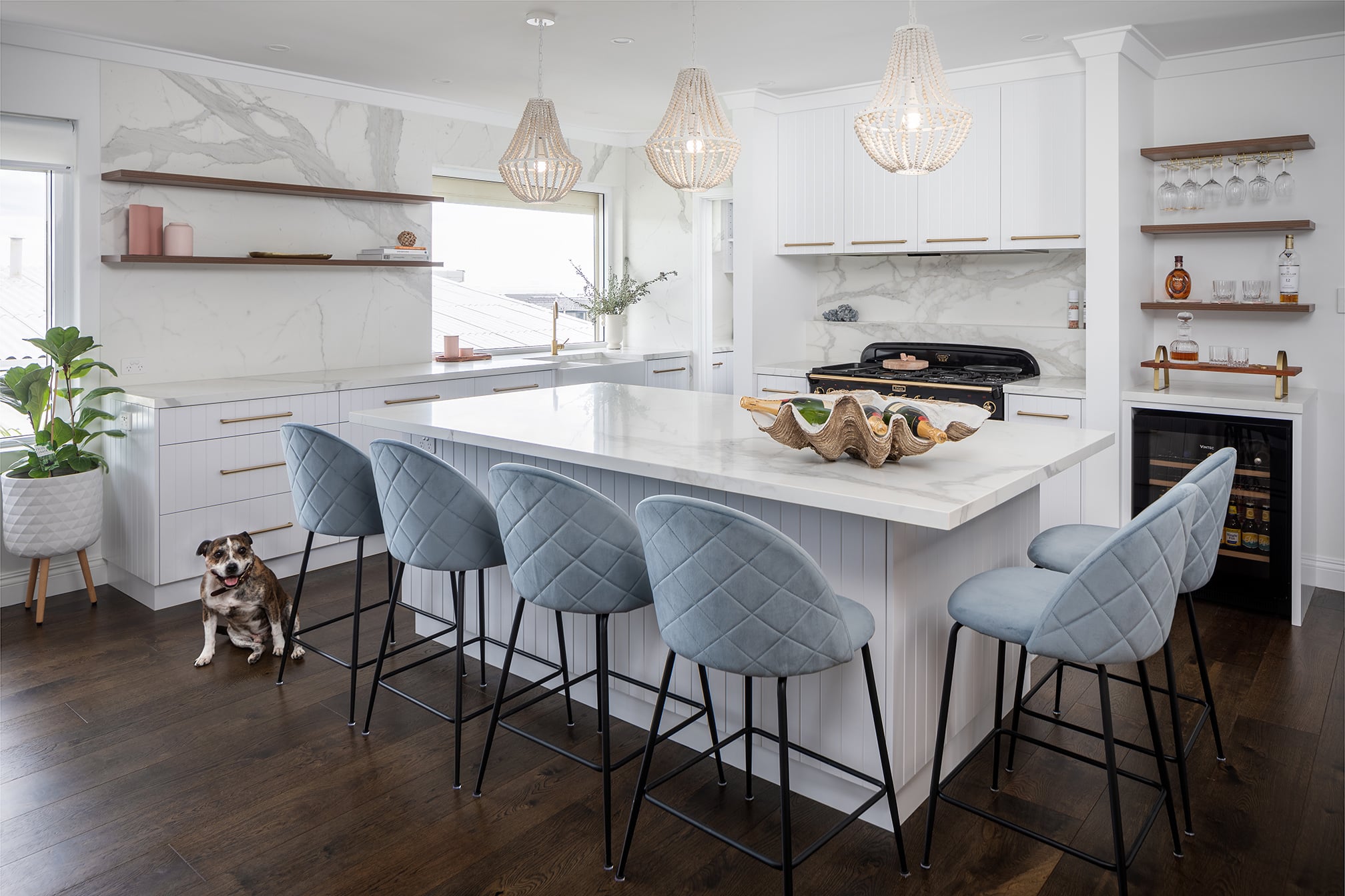 North beach coastal barn kitchen that is light and bright with dark timber flooring, a feature falcon oven and white stone look benchtops.