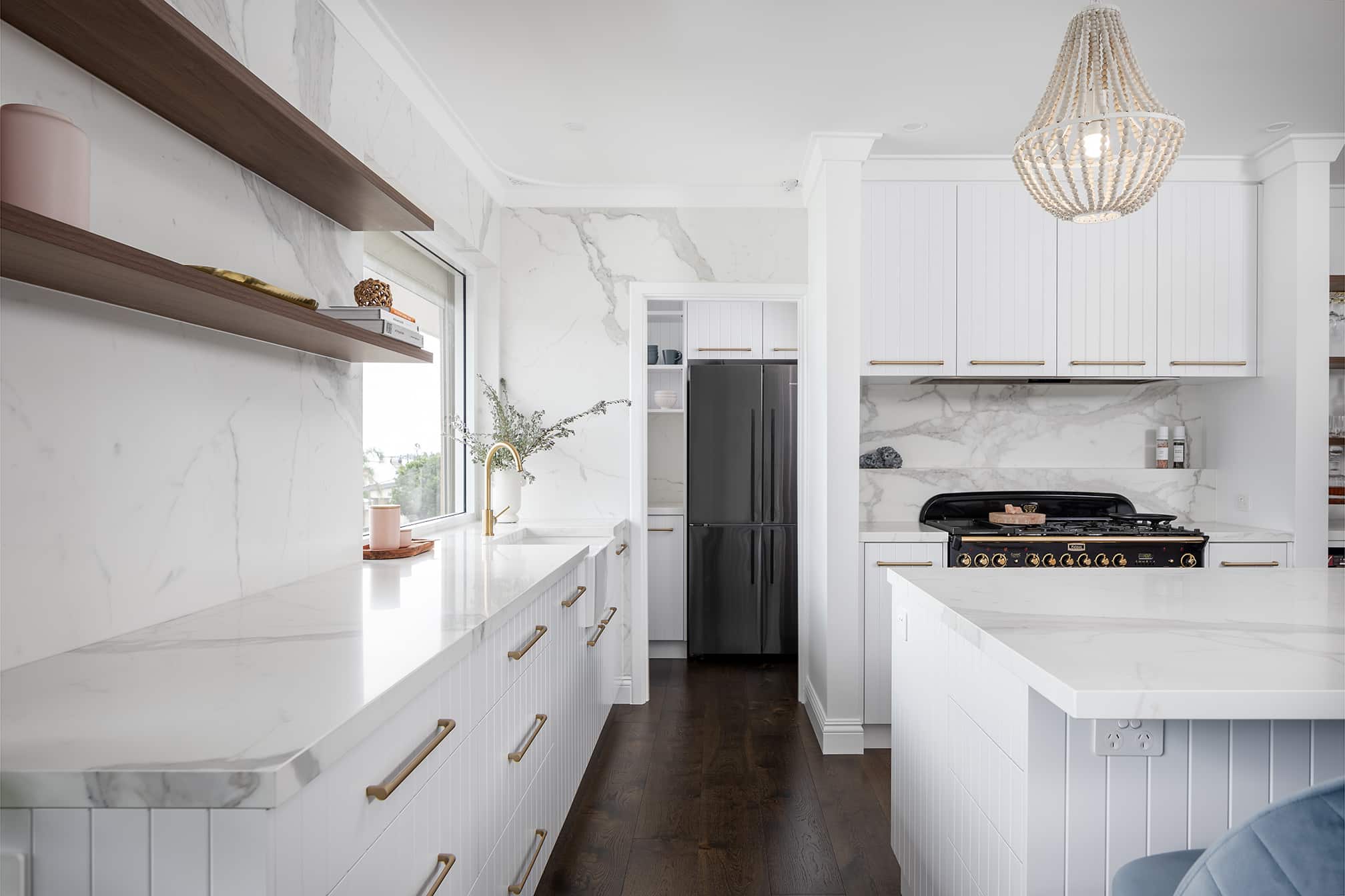 North beach coastal barn kitchen view down the left hand side with sink, integrated dishwasher, shelving and view into the walk in pantry.