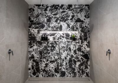 Scarborough ensuite with striking black and white patterned tile shower wall