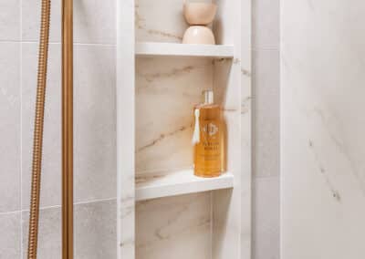 Mount Lawley Traditional Skylit Ensuite - Close up of shower niche in stone look tile and brass shower head