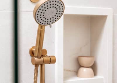 Mount Lawley Traditional Skylit Ensuite - Close up of shower niche in stone look tile and brass shower head