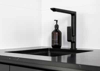 Monochrome Laundry black tapware and black undermount sink on black engineered stone benchtop