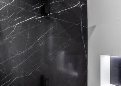 Monochrome ensuite feature black stone look panel in shower