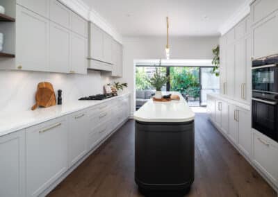 Contemporary shaker style kitchen with curved island bench in a galley layout