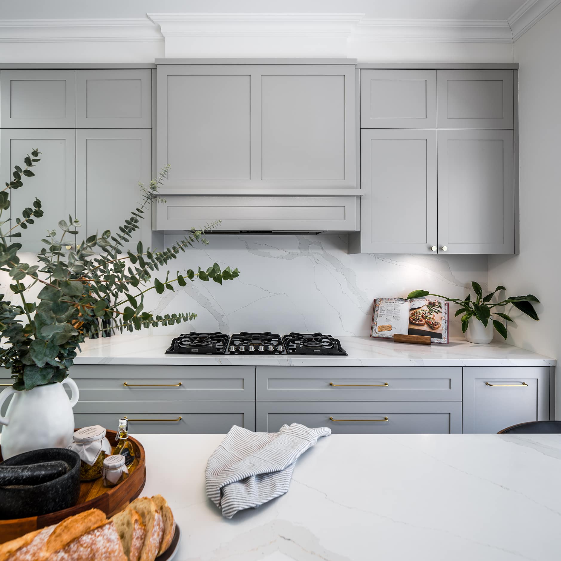 contemporary shaker style kitchen with brass tapware and feature rangehood