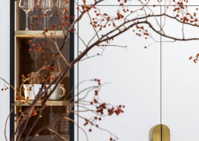 Integrated fridge cabinetry, tall glass cabinetry and styling flowers