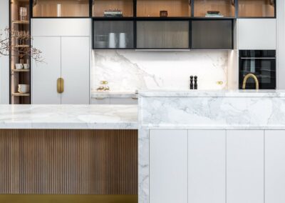 Contemporary kitchen with oak timber cabinetry, fluted glass, brass hardware and marble benchtops.