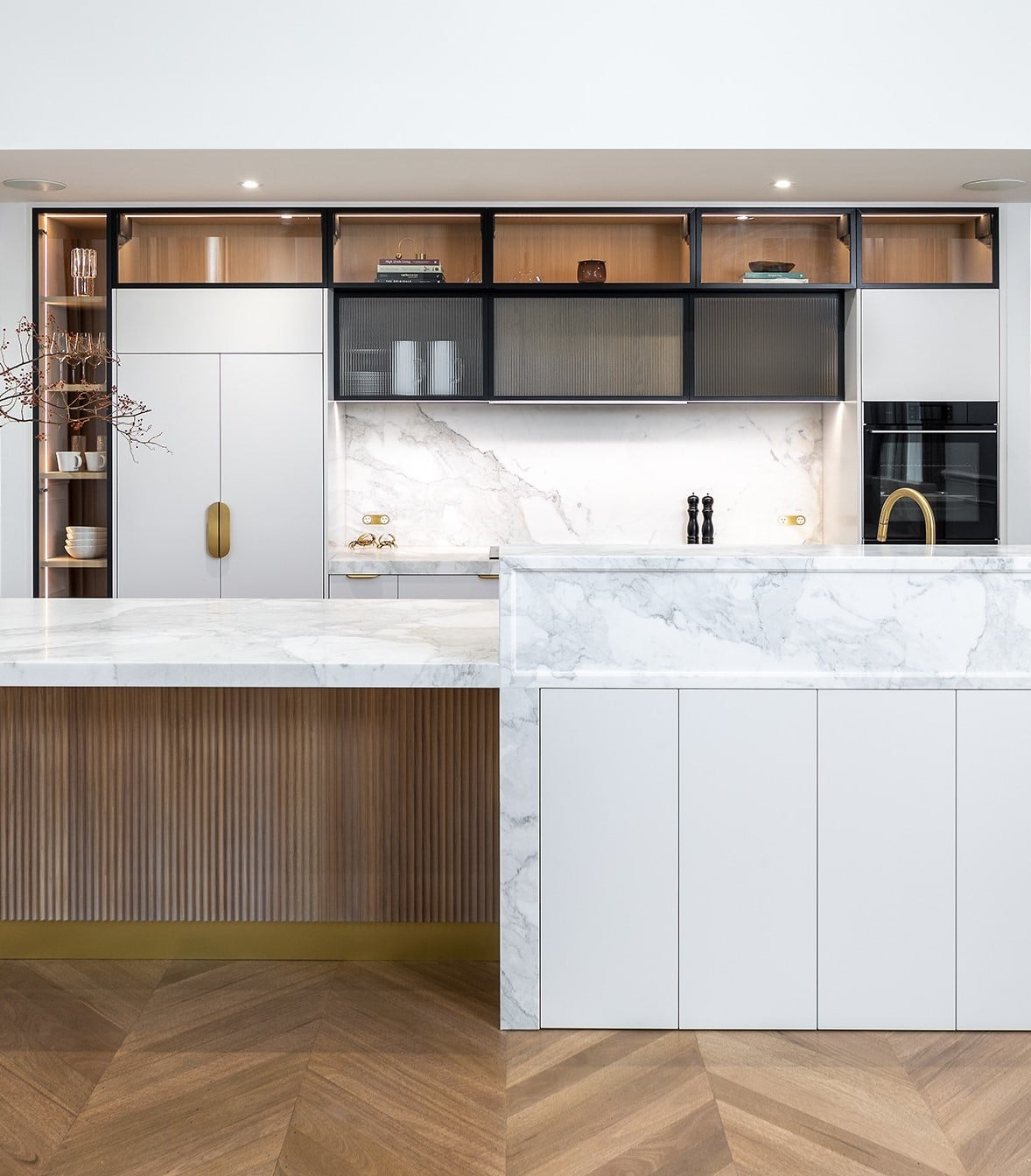 Contemporary kitchen with oak timber cabinetry, fluted glass, brass hardware and marble benchtops.