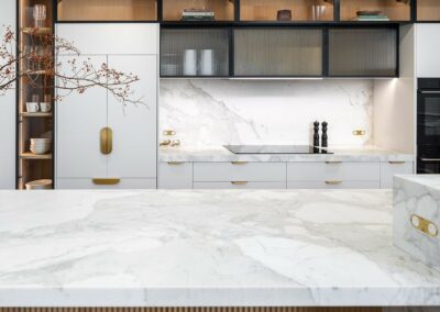 Contemporary kitchen with oak timber cabinetry, fluted glass, brass hardware and marble benchtops.