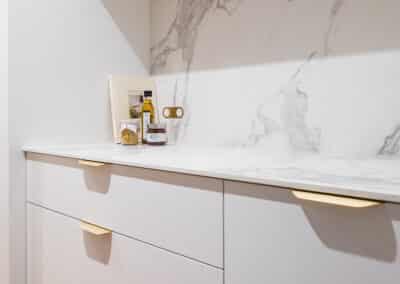 Walk in pantry with marble benchtops and brass hardware