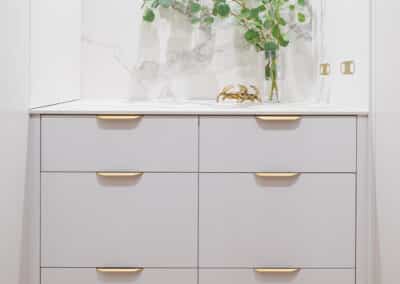 Walk in pantry with marble benchtops, drawer cabinetry and brass hardware