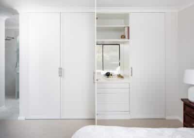 Built in wardrobe with mirror splashback, benchspace and drawers