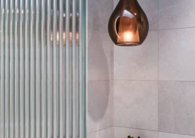 Contemporary ensuite renovation with bronze pendant light and fluted shower screen