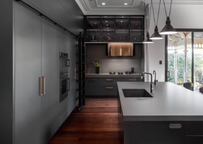 Industrial style kitchen renovation with black cabinetry and lighting