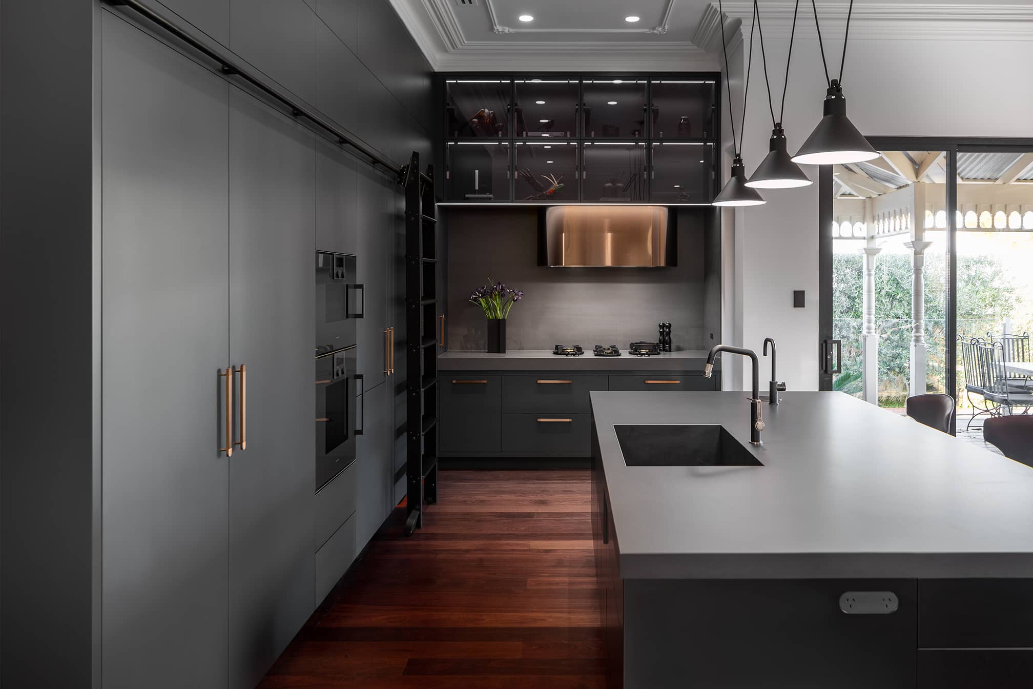 Industrial style kitchen renovation with black cabinetry and lighting