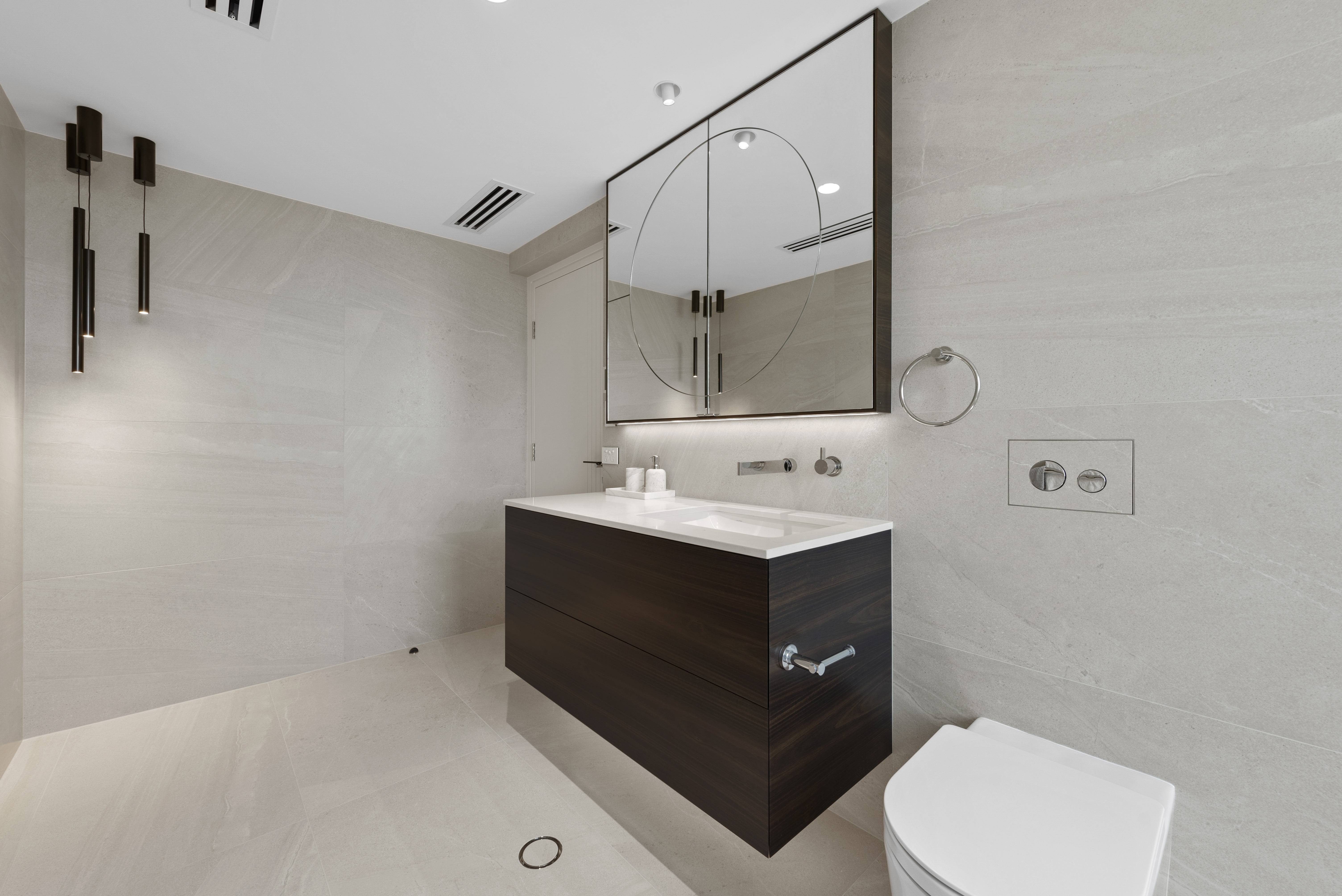 North Beach Coastal Barn Bathroom with brass tapware, pink concrete basins, V Groove panelled cabinetry and Onyx stone look tiles with a feature chevron pattern