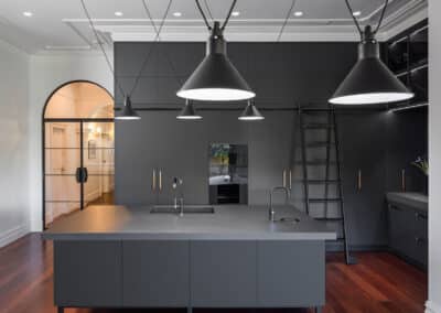 Industrial style kitchen renovation with black cabinetry and lighting