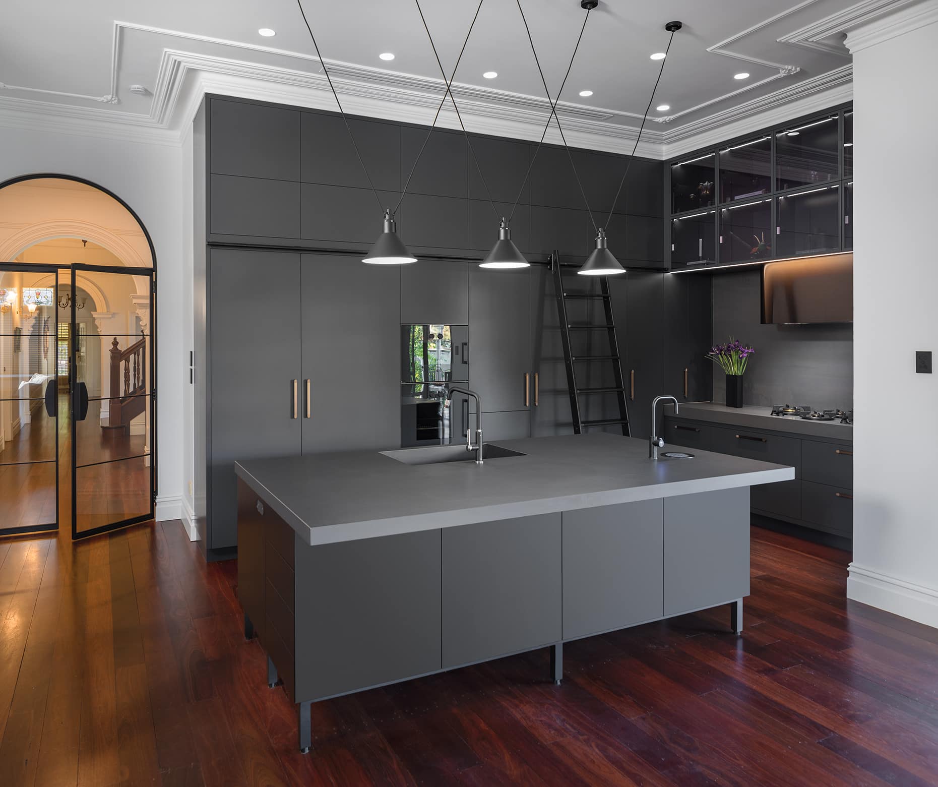 Industrial style kitchen renovation with black cabinetry and lighting