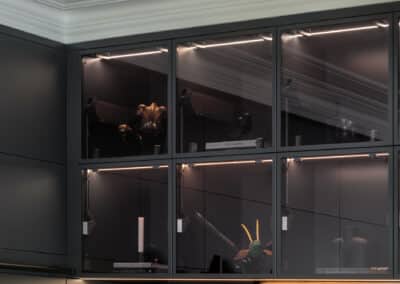 Industrial style kitchen renovation with black glass overhead cabinets