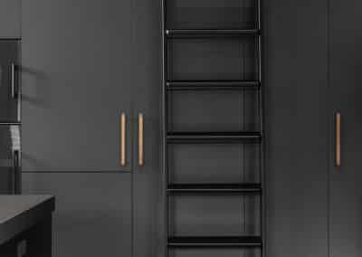 Industrial style kitchen renovation with black cabinetry and rolling library ladder