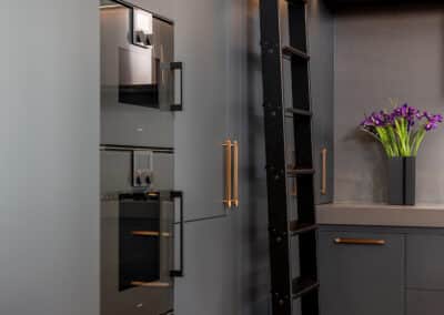 Industrial style kitchen renovation with black cabinetry and rolling library ladder