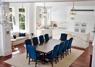 Riley project kitchen renovation with seamless minimalist cabinetry design and a marble look bookmatched island bench with dining blue chairs