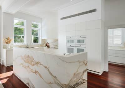 Riley project kitchen renovation with seamless minimalist cabinetry design and a marble look bookmatched island bench on right angle