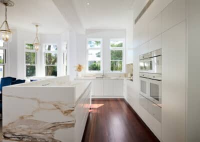 Riley Project kitchen renovation with seamless minimalist cabinetry design and a marble look bookmatched island bench behind island