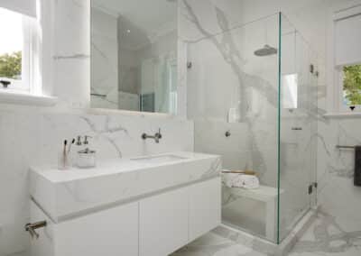 Contemporary marble look upstairs bathroom close up of shower and vanity