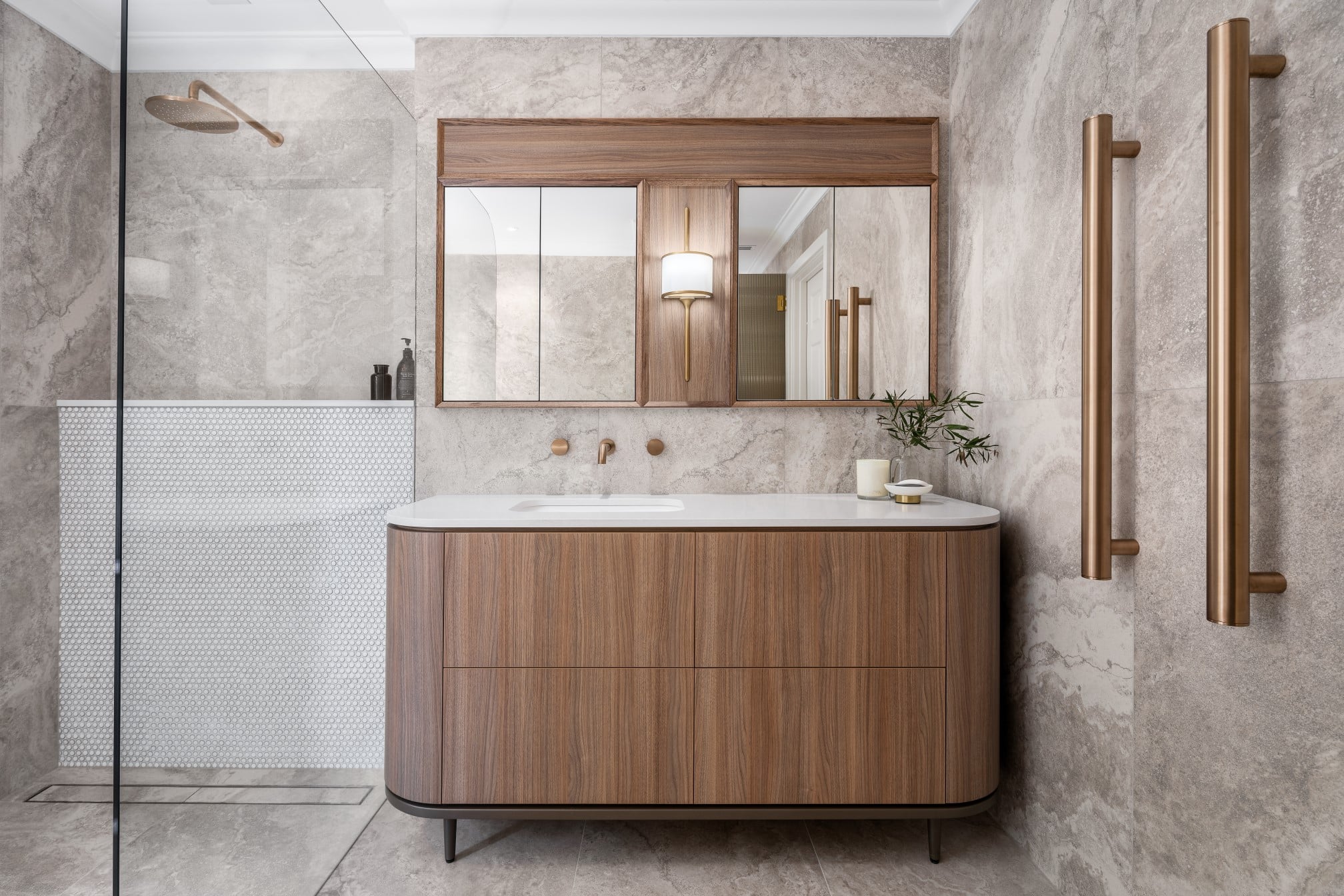 Mid-century modern contemporary vanity front wtih curved edges, seamless drawer fronts and bespoke mirrored cabinetry above with bronze tapware