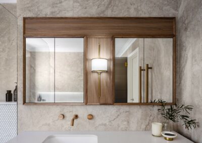Mid-century modern contemporary mirrored cabinetry above vanity with Mona brass light and bronze tapware
