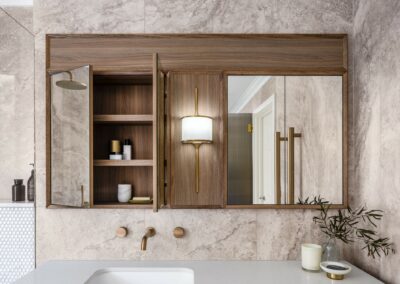 Mid-century modern contemporary mirrored cabinetry above vanity with Mona brass light and bronze tapware open cabinet