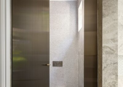 Bronze reeded glass screen door for toilet enclosure with brushed nickel flush button