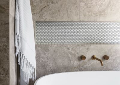 Mid-century modern contemporary ensuite reno with free standing bath, bronze tapware and recessed niche close up with towel hanging