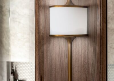 Close up of Mona brass feature light within mirrored cabinetry