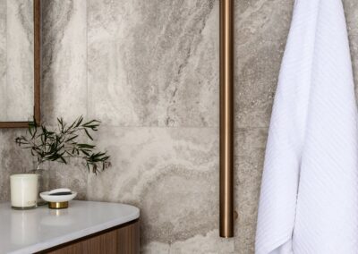 Walnut vanity side with bronze vertical heated towel rails