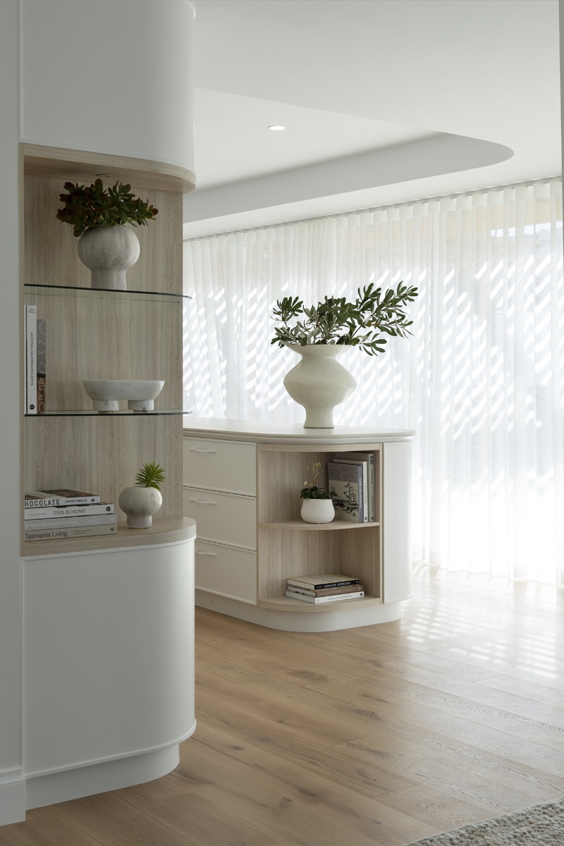 Contemporary curved renovation, curved walls with timber shelves.